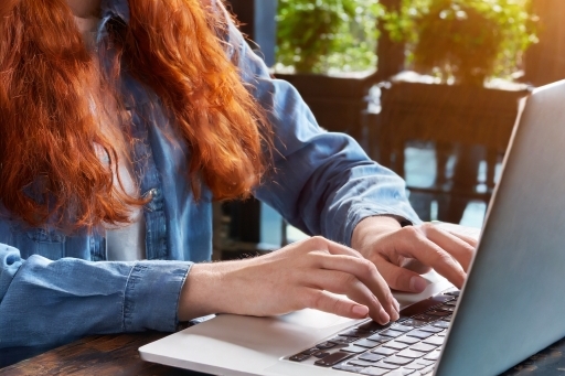 a red haired woman coding outdoors